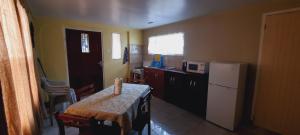 een kleine keuken met een tafel en een koelkast bij Hanna's Apartment Paramaribo in Paramaribo