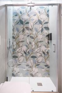a bathroom with a shower with a floral wallpaper at Dimora Angioina in Naples