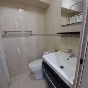 a white bathroom with a toilet and a sink at Hermoso 1Hab+2baños apartamento en el Bosque,Ccs in Caracas