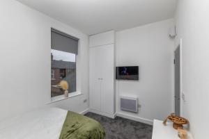 a bedroom with a bed and a tv on a wall at Kilwick Lodge, Hartlepool City Centre, Room Stay in Hartlepool