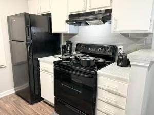a kitchen with a black stove and a refrigerator at Home Theater Sleeps 8 WiFi in Morrow