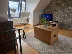 a living room with a wooden box and a chair at Creel Cottage (No.3) in Arbroath