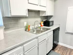 a kitchen with a sink and a microwave at Home Theater Sleeps 8 WiFi in Morrow