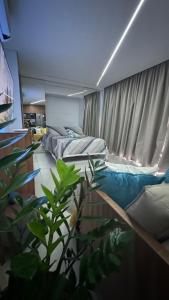 een slaapkamer met 2 bedden en een plant bij Studio luxo na Barra para 4 Pessoas in Salvador