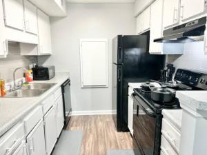 a kitchen with white cabinets and a black refrigerator at Home Theater Sleeps 8 WiFi in Morrow