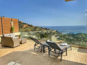 een patio met een tafel en stoelen en de oceaan bij Villa Balcony, Cozy Villa with Amazing View in Rodhiá