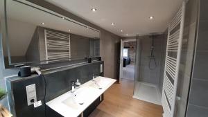 a bathroom with two sinks and a shower at Ferienwohnung Plintho in Oberthal