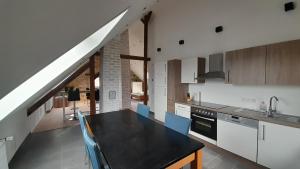 eine Küche mit einem schwarzen Tisch und einem Dachgeschoss in der Unterkunft Ferienwohnung Plintho in Oberthal