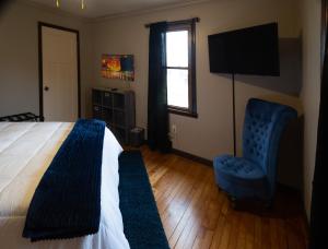 ein Schlafzimmer mit einem Bett, einem Stuhl und einem TV in der Unterkunft Near Sundown Mountain and Chestnut Mountain Resorts in Dubuque