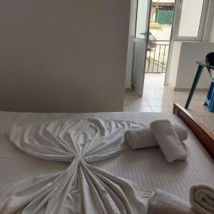 uma cama branca com duas toalhas em cima em Casa Mia Economy Condos em Sarandë