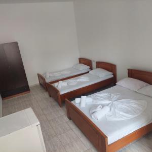 um grupo de três camas num quarto em Casa Mia Economy Condos em Sarandë
