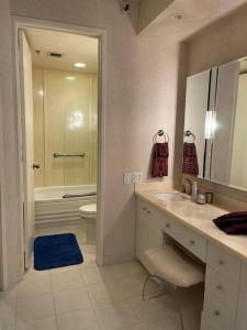 a bathroom with a sink and a toilet and a mirror at Honolulu Minimum 30-Nite Rental 3 bed room 2 parking in Honolulu