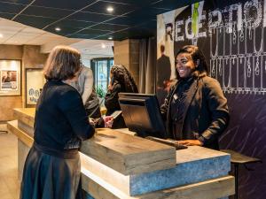 two women standing at a desk with a computer at ibis budget Paris Porte de Bercy in Charenton-le-Pont