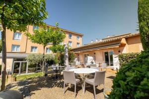 a patio with a table and chairs and a building at Best Western H&ocirc;tel Le Sud in Manosque