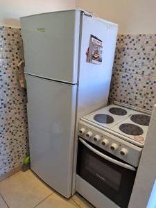 una nevera blanca junto a una estufa en la cocina en Hermoso departamento entero 2 Dormitorios con cochera B Urca en Córdoba