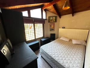 a bedroom with a bed in a room with windows at Hermosa casa en Algarrobo in San Antonio