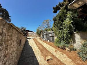 an alley with a stone wall and a fence at Hermosa casa en Algarrobo in San Antonio