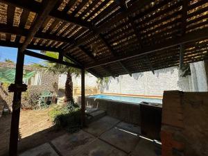 a patio with a wooden pergola and a swimming pool at Hermosa casa en Algarrobo in San Antonio