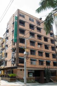 un edificio de ladrillo con una señal verde delante de él en Hotel Portón Sabaneta, en Sabaneta