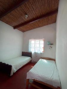 een kamer met 2 bedden en een raam bij FINCA JAZMIN in Monsefú
