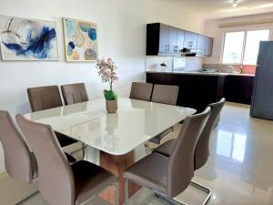 a dining room with a white table and chairs at Tres dormitorios sector Wyndham y la Quadra in Manta