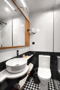 a bathroom with a toilet and a sink and a mirror at Soho Athinas 60 in Athens