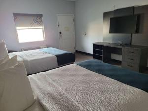 Habitación de hotel con 2 camas y TV en Studio 6 Gonzales TX en Gonzales