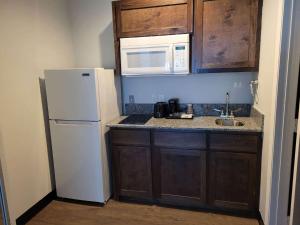 a kitchen with a white refrigerator and a microwave at Studio 6 Gonzales TX in Gonzales