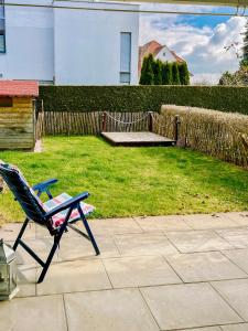 una silla sentada en un patio junto a un patio en EulenNest Spacious Cozy Home with Private Garden en Lindenberg im Allgäu