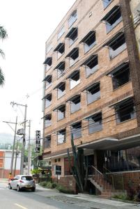 a building with a car parked in front of it at Hotel Portón Sabaneta in Sabaneta