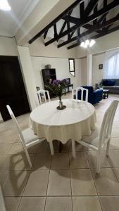 einen weißen Tisch mit Stühlen und eine Vase mit Blumen darauf in der Unterkunft Apartamento Maracuyá en Tarija in Tarija