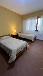 a bedroom with two beds and a window at Apartamento Maracuyá en Tarija in Tarija