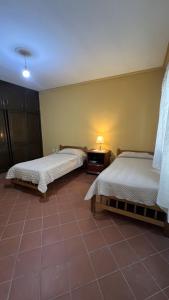 a bedroom with two beds and a tiled floor at Apartamento Maracuyá en Tarija in Tarija