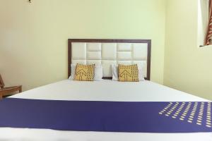 a bedroom with a large bed with blue and white sheets at OYO Hotel Star Inn in Sohāna
