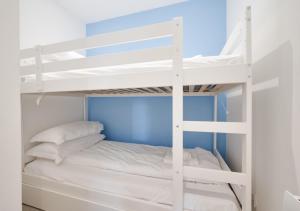 a bunk bed with white bunk beds in a room at Redcliffe Apartment L in Bishopston