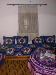 ein Schlafzimmer mit einem Bett mit Kissen und einem Fenster in der Unterkunft Dar Dyafa in Er Rachidia