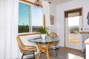 a dining room with a table and chairs and a window at Desert Escape+Art studio+Trailer in Sunfair Heights