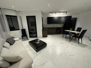 een woonkamer met een bank en een tafel met stoelen bij Luxury appartement in La Marsa