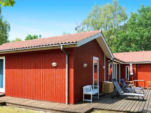 Oddeにある6 person holiday home in Hadsundの赤い家(デッキ、テーブル、椅子付)