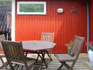 Oddeにある6 person holiday home in Hadsundの木製テーブル、パティオ(椅子2脚付)