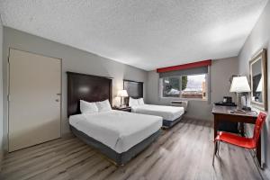 a hotel room with two beds and a desk and a door at Royal Pagoda Motel Dodger Stadium in Los Angeles