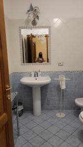 a person taking a picture of a bathroom with a sink at BnB Villa Melany vicino Centro in Lucca