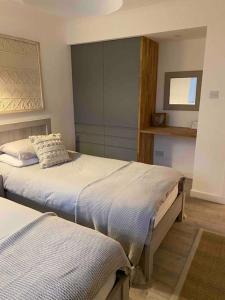 1 dormitorio con 2 camas y espejo en Creel Cottage (No. 4), en Arbroath