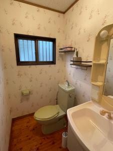 a bathroom with a toilet and a sink and a window at YAKUSHIMA YUDOMARI443 in Yudomari