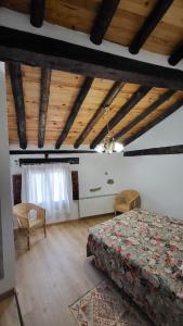 a bedroom with a bed and a wooden ceiling at La Casona de Roser in Cardenete