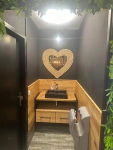 La salle de bains est pourvue d'un lavabo et d'un cœur sur le mur. dans l'établissement Kuisto, à Montpellier