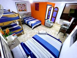 Cette chambre comprend 3 lits et un canapé. dans l'établissement Hostal Ocean Pacifico, à Punta Negra