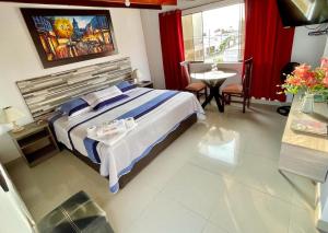 Habitación de hotel con cama, mesa y mesa en Hostal Ocean Pacifico, en Punta Negra