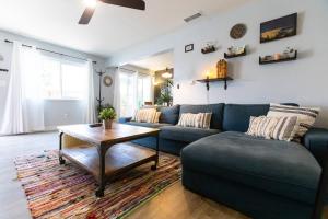 a living room with a blue couch and a table at Cali Condo+BBQ+MemoryFoamBeds+12min to Beach in San Juan Capistrano