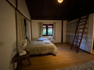 a bedroom with a bed with a ladder and a window at Amanduarte Brasília in Brasilia